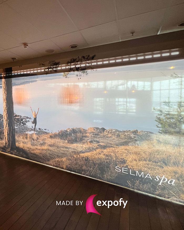 Stor tygvepa med naturlandskap och logotyp för Selma Spa, monterad längs en innervägg.